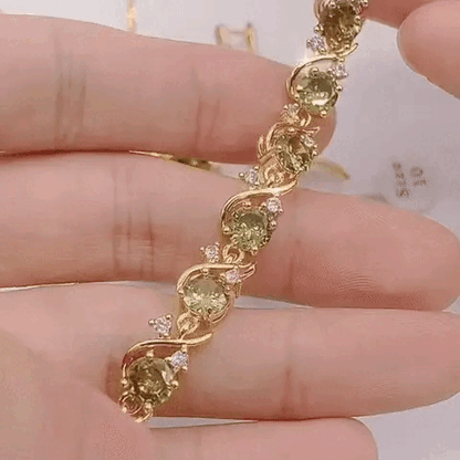 Close-up of luxury peridot jewelry set bracelet with gold and green peridot gemstones held in hand