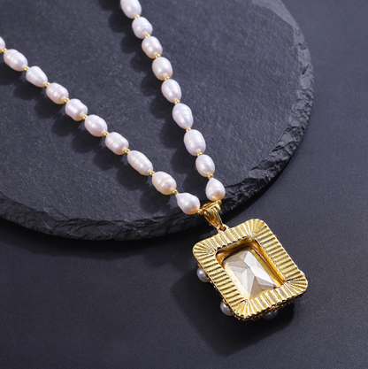 Elegant pearl jewelry set featuring a gold rectangular pendant with a geometric design on a pearl bead necklace